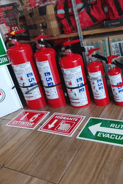 Extintores PQS en exhibición con señalética de extintor, hidrante y ruta de evacuación en sucursal LAMAR